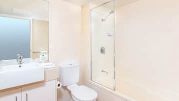 Une salle de bain moderne avec une douche à parois de verre, un lavabo blanc et des toilettes.