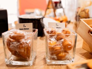 Deux récipients en verre contenant des aliments, dont l’un est étiqueté « Sans gluten » et l’autre « Gluten », sont posés sur une table en bois.