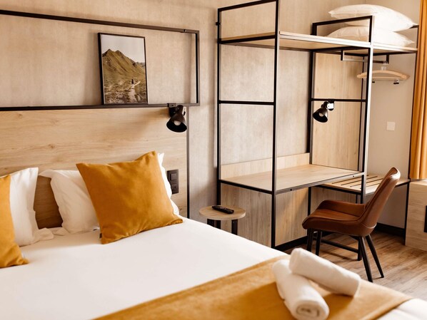 A hotel room with a bed, a desk, a chair, and a shelf unit. - Ibis Clermont Ferrand A71 A75 La Meridienne (Clermont-Ferrand)