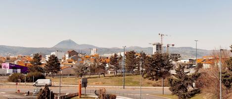 A parking lot with cars, a construction site, and buildings in the background.