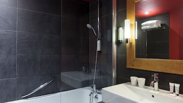 Une salle de bain moderne avec une douche à parois de verre, un lavabo blanc et un grand miroir.