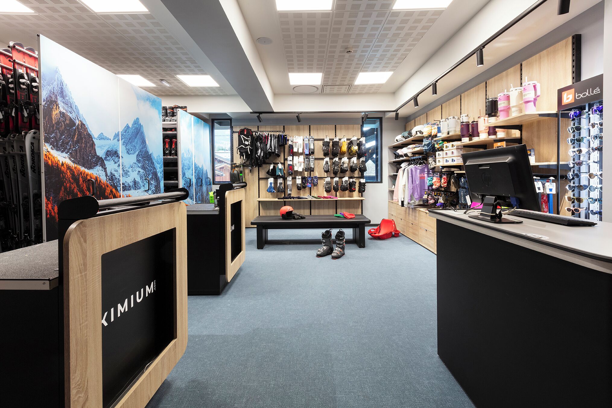 A ski equipment store with wooden display shelves, a reception desk, and a bench.