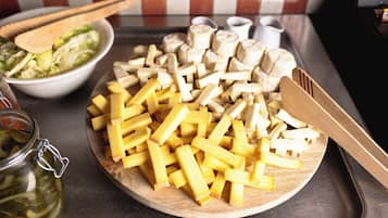 A wooden cutting board with cheese and mushrooms on a kitchen counter.