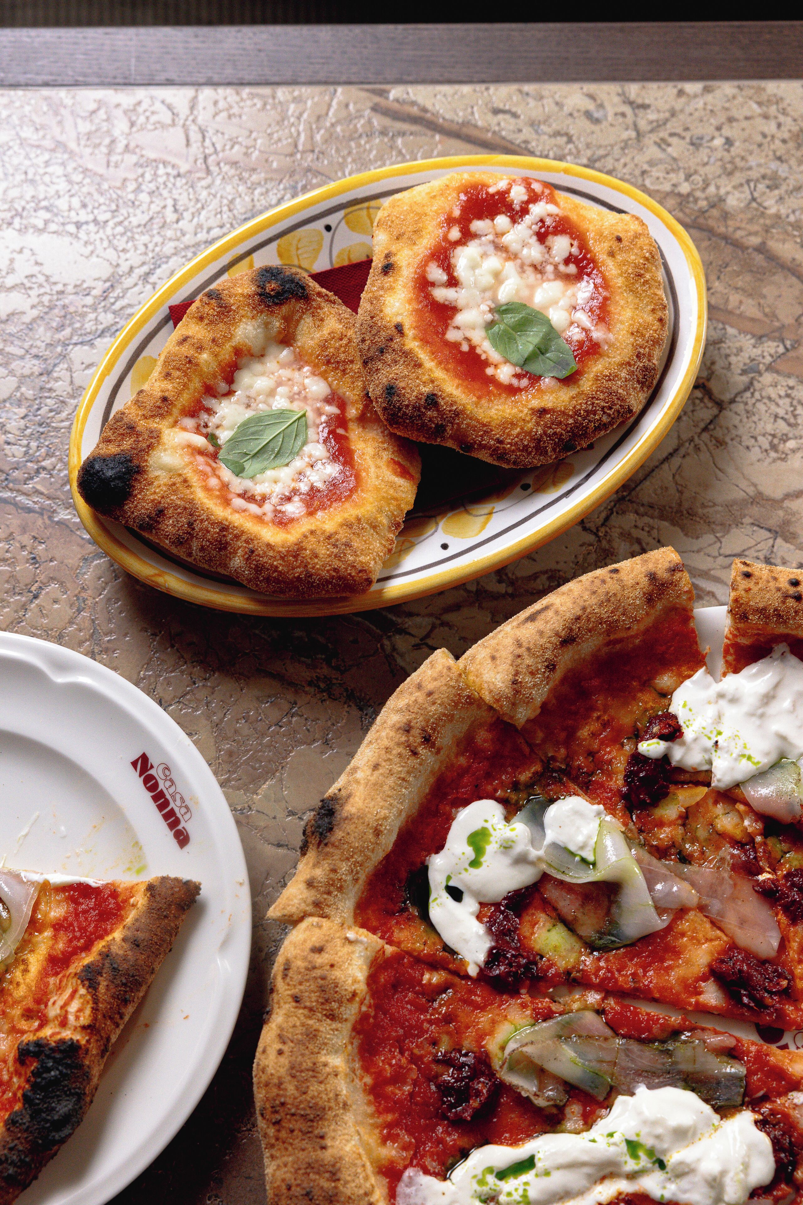 A pizza with toppings and a bowl of breaded food.