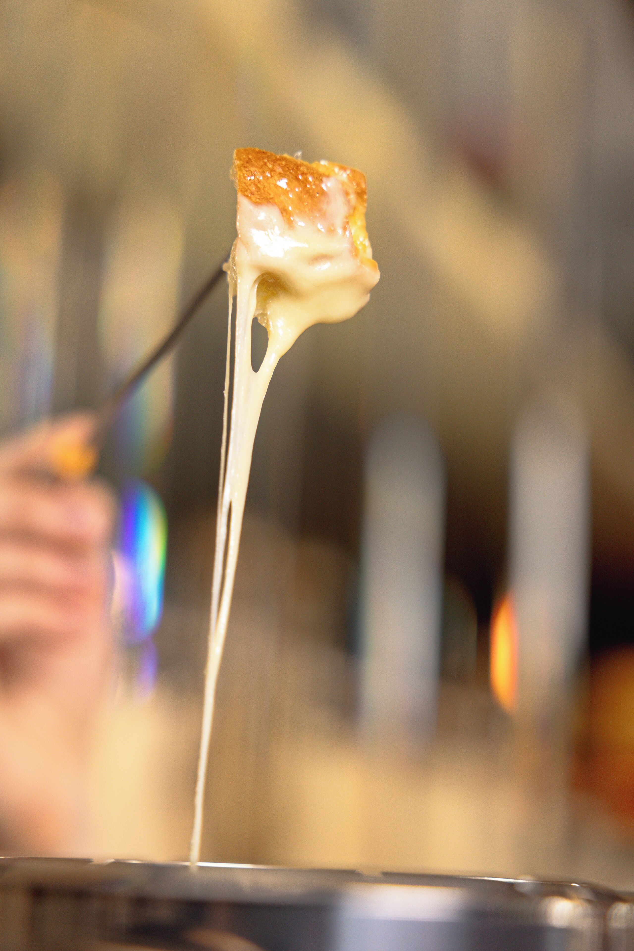 A close-up of a dessert with a golden-brown top, likely a caramelized marshmallow or similar treat, being lifted by a fork.