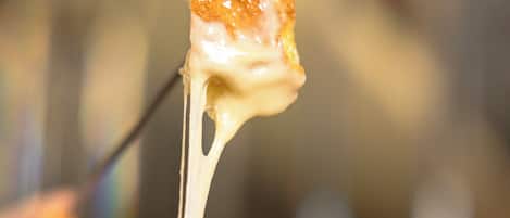 Primer plano de un postre con la parte superior dorada, posiblemente un malvavisco caramelizado u otra golosina similar, que se levanta con un tenedor.