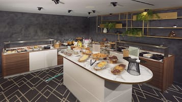 A modern breakfast bar with various pastries and breakfast items.