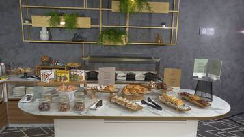 Um buffet de café da manhã com diversas opções de comida e um espaço para café.