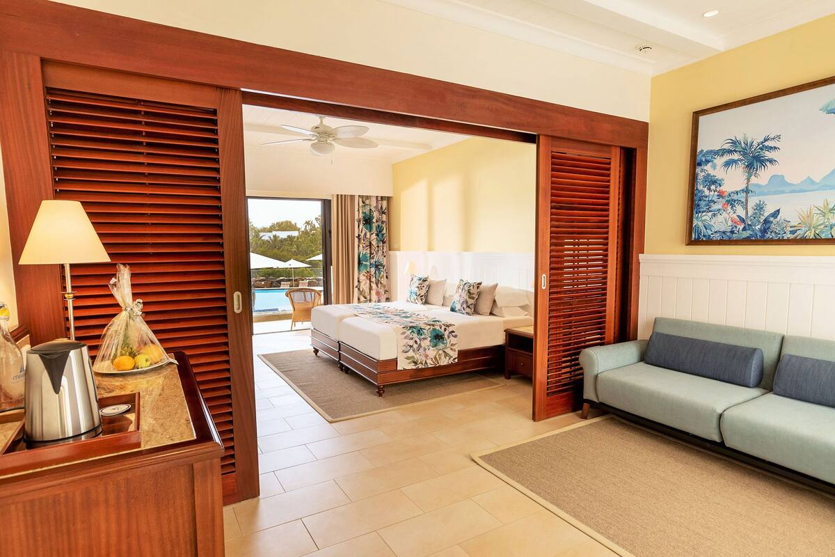 Ein Hotelzimmer mit Bett, Sofa, Kaffeemaschine und Blick ins Freie.