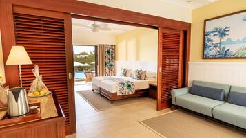 Habitación de hotel con cama, sofá, cafetera y vista al exterior.