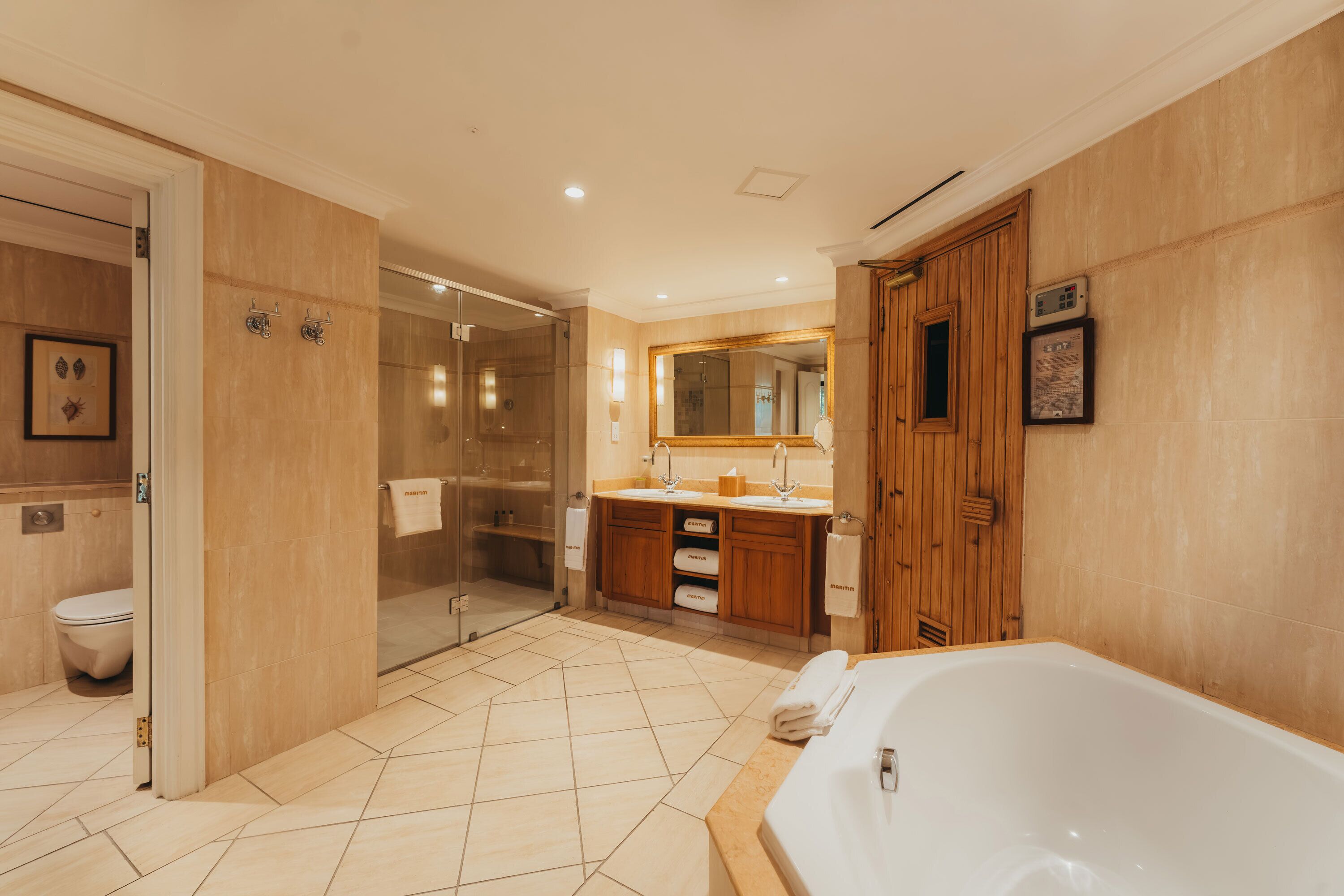 A modern bathroom with a walk-in shower, a large bathtub, and a wooden vanity with a mirror.