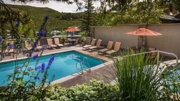 Relax by the serene pool surrounded by lush greenery and comfortable lounge chairs.