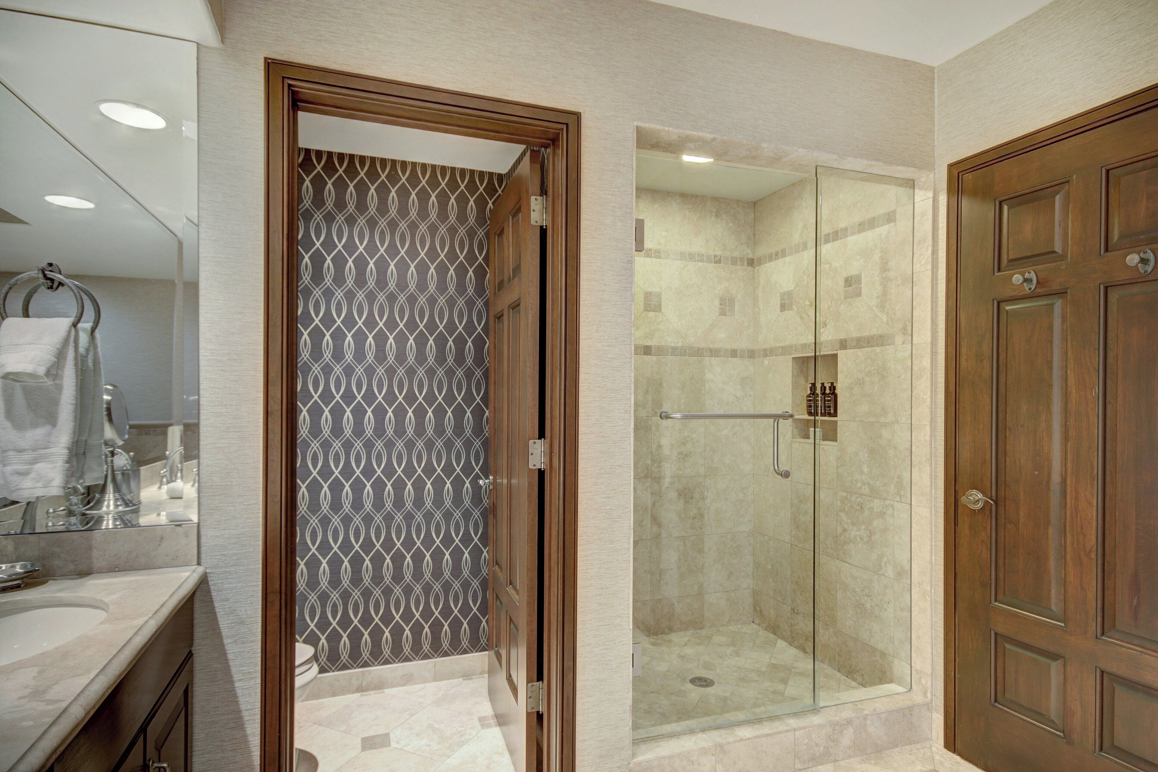 A bathroom with a shower, a toilet, and a sink.