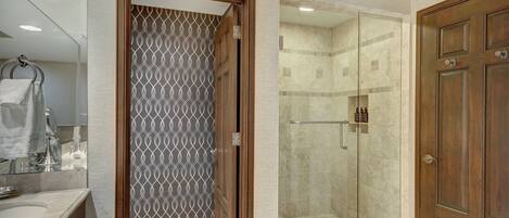 A bathroom with a shower, a toilet, and a sink.
