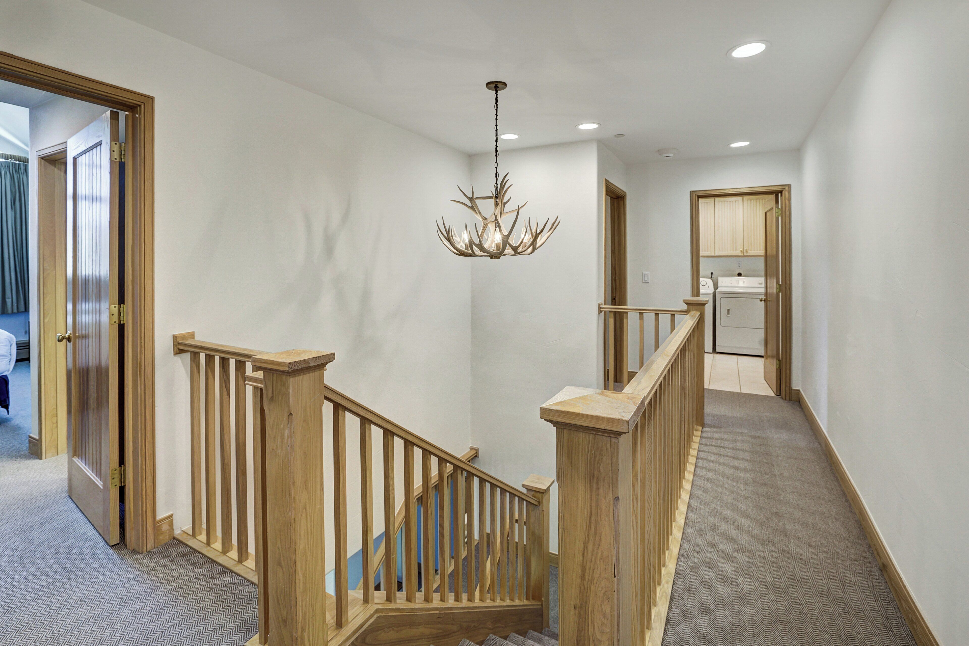 A staircase with wooden railings and a chandelier.