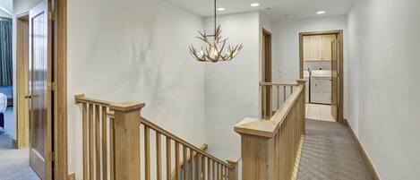 A staircase with wooden railings and a chandelier.