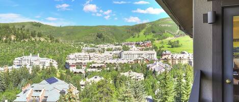 A resort with multiple buildings surrounded by trees and hills.