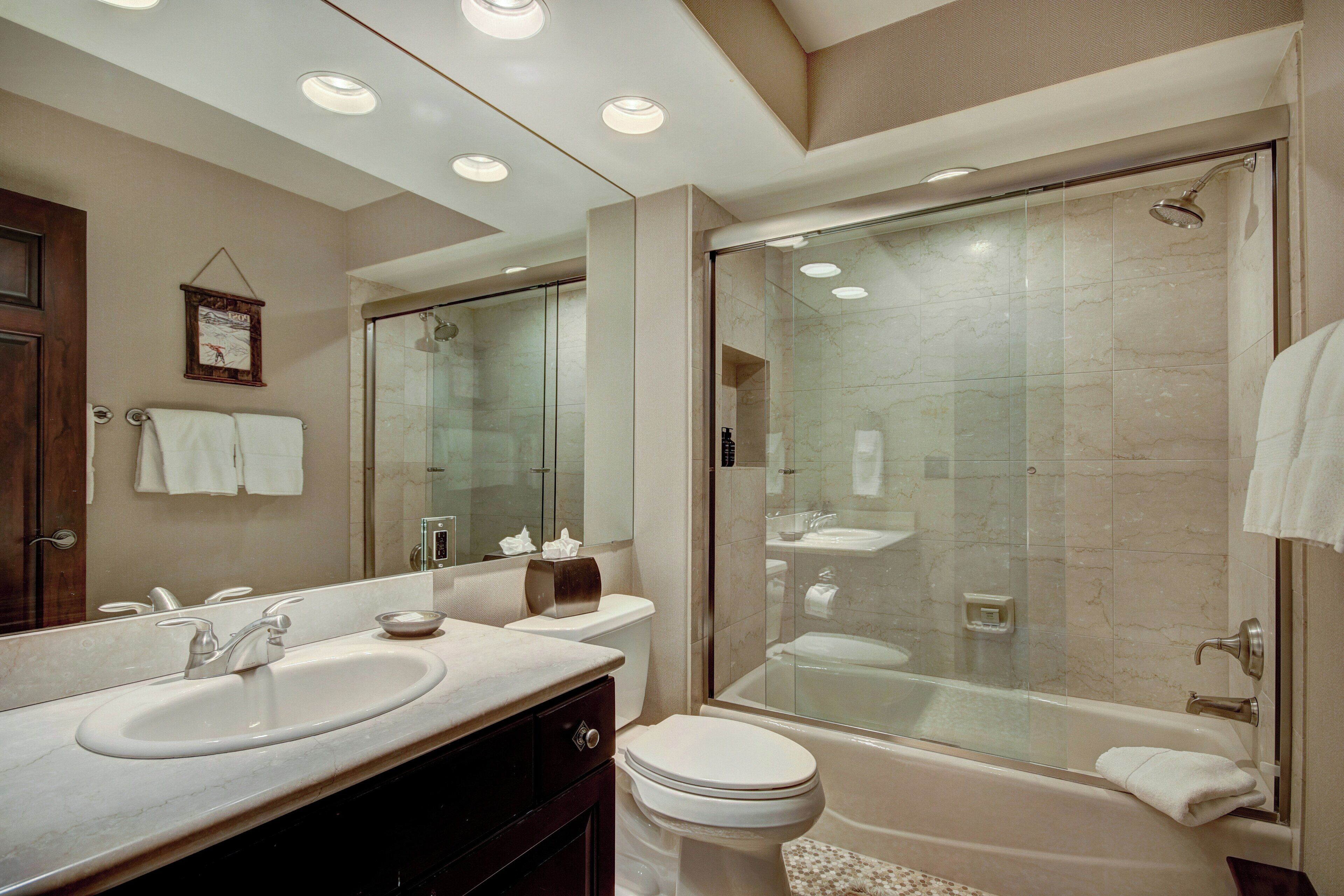 A modern bathroom with a large sink, toilet, and bathtub.