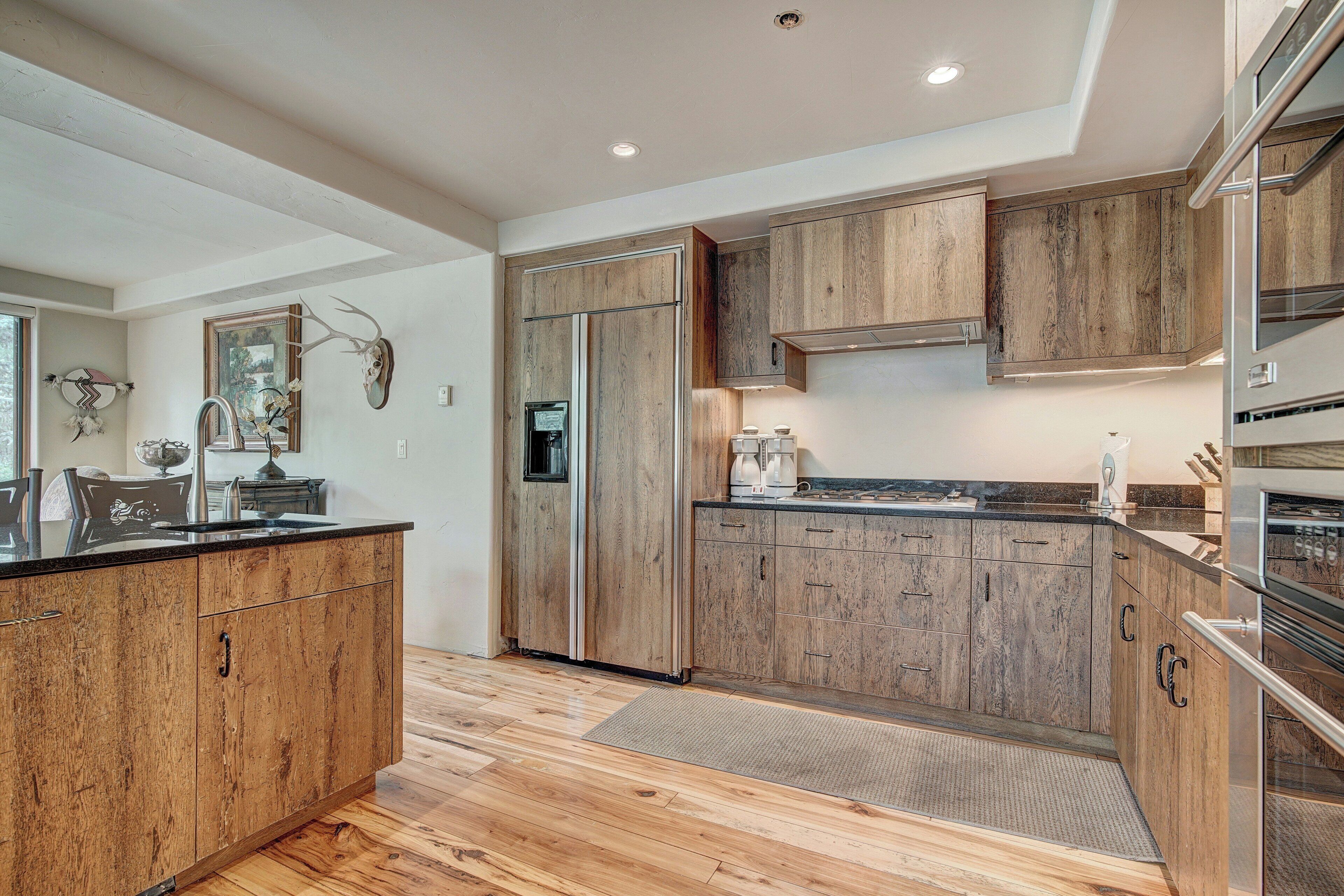 A modern kitchen with wooden cabinets, stainless steel appliances, and a large island.