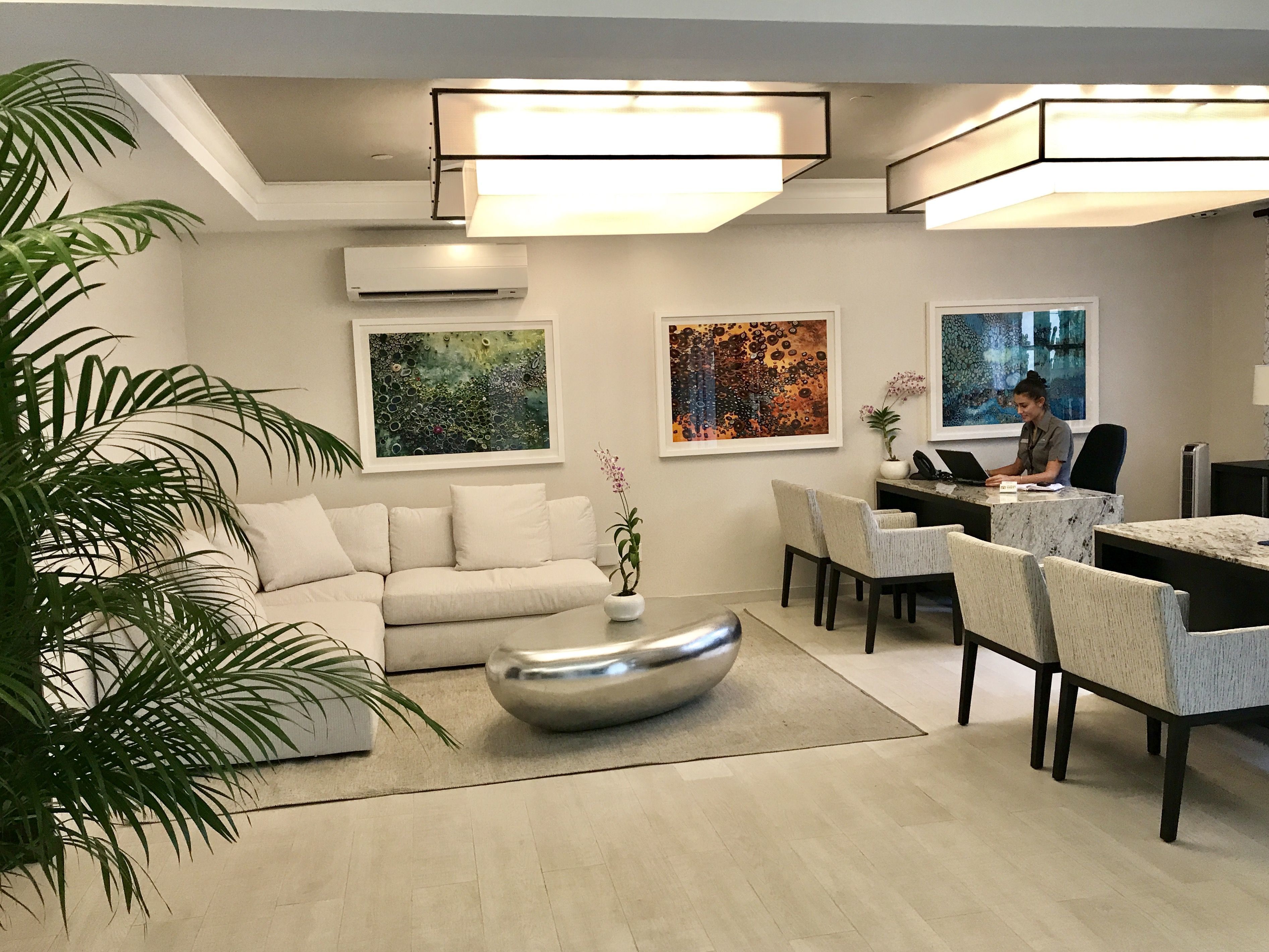 A modern living room with a sofa, dining area, and artwork on the walls.