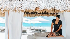 A beachside massage area with a thatched roof, white curtains, and a view of the ocean. - Bucuti & Tara Beach Resort - Adults Only (Oranjestad)