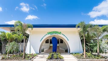 A hotel entrance with a blue roof, white walls, and a sign reading "Maracataville Costa Rica".