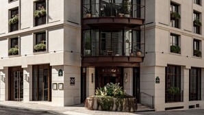A multi-story hotel with a central dome, balconies with plants, and a classic architectural design. - Norman Paris Hôtel & Spa (Paris)