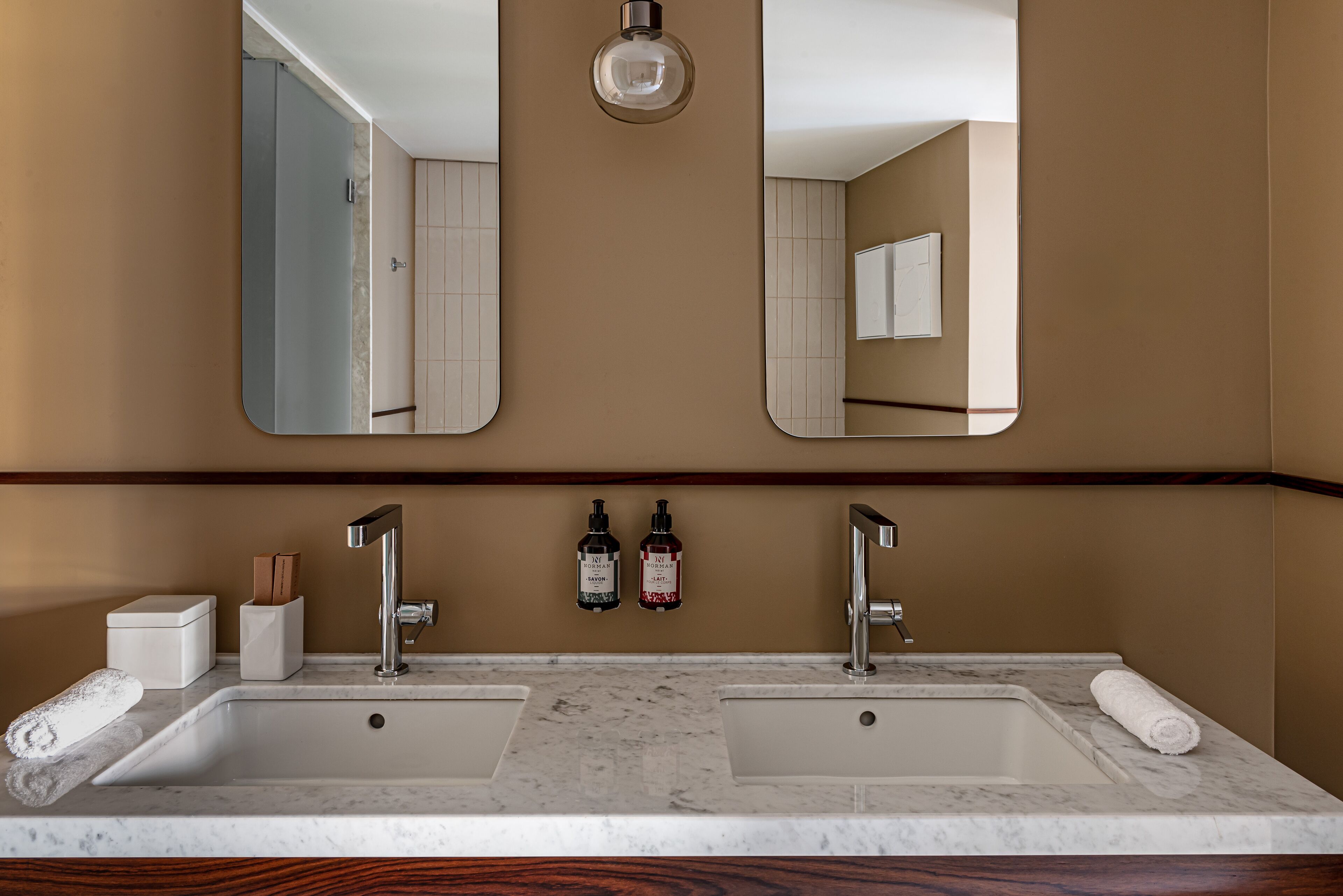 A bathroom with two sinks, a mirror, and a towel on the counter.