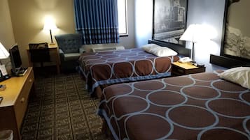 A hotel room with two beds, a desk, a chair, a lamp, and a large painting on the wall.