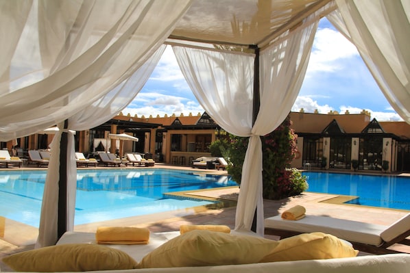 A poolside area with lounge chairs and a view of a swimming pool.