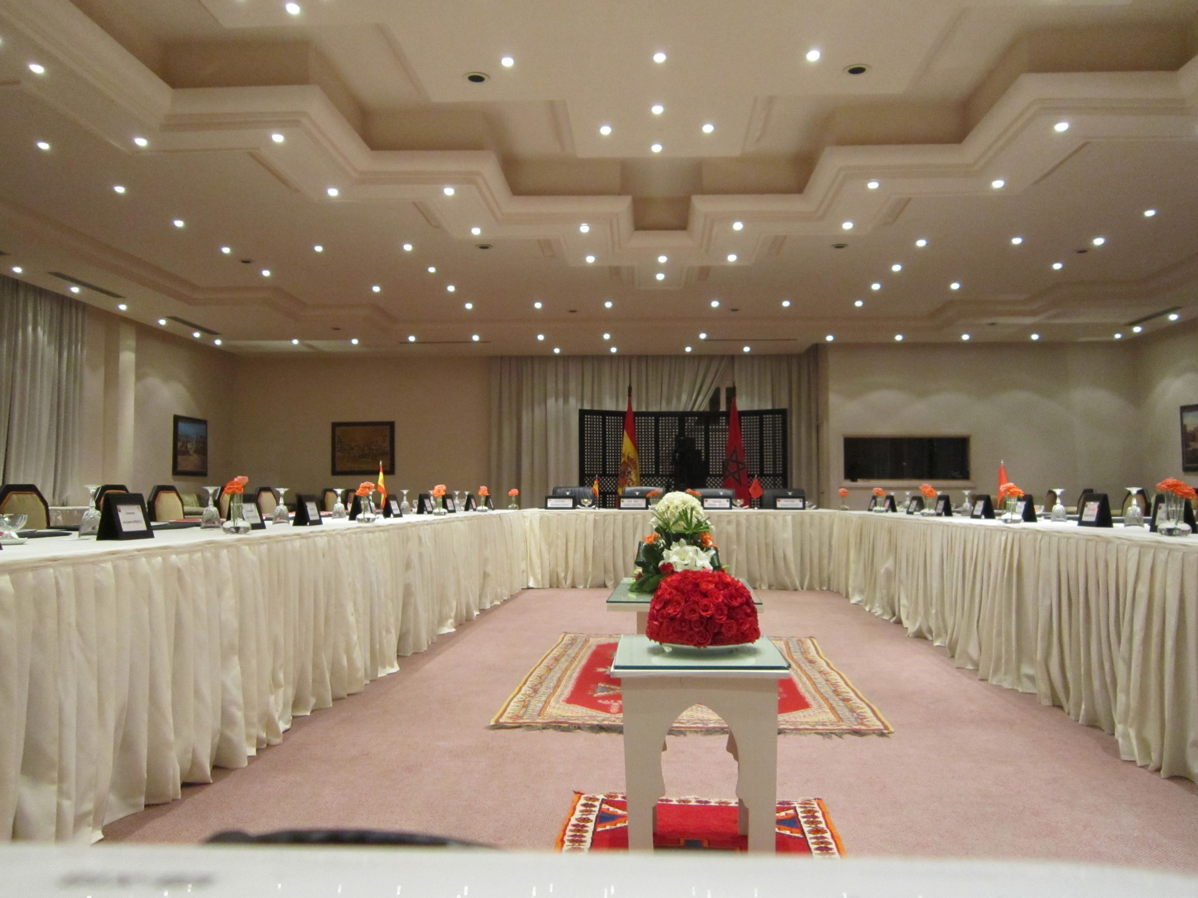 A conference room with a long table, chairs, and a podium.