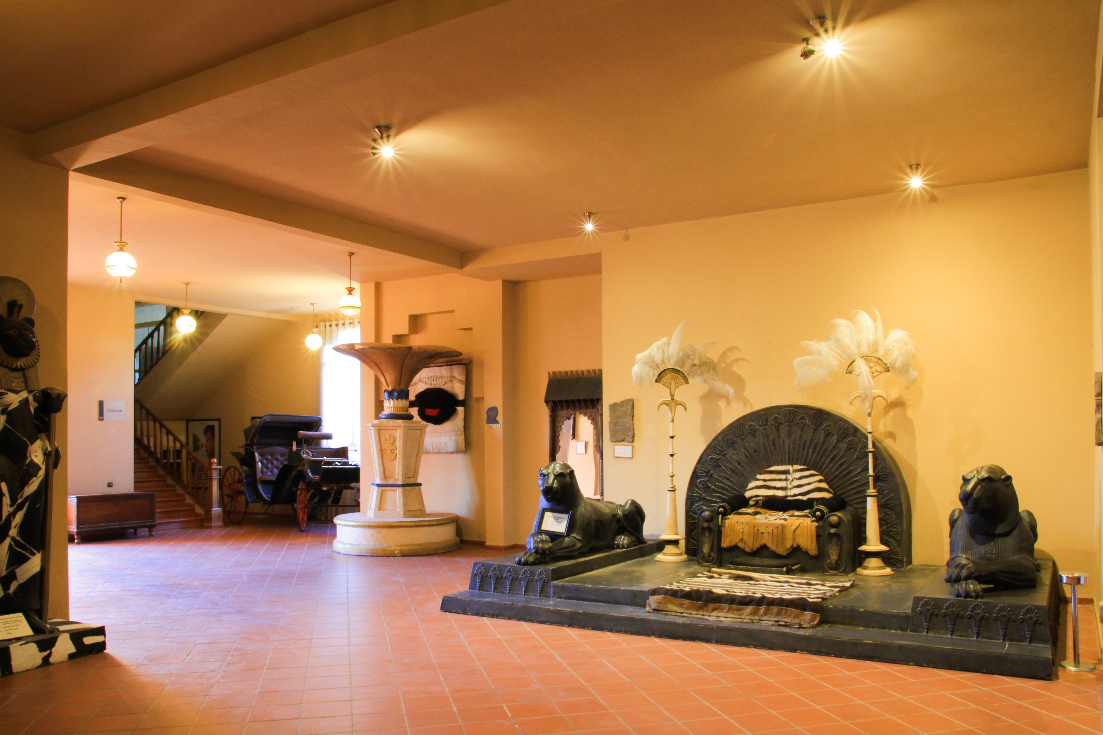 Un hall amplio con chimenea, una escalera y una exhibición de artefactos históricos.