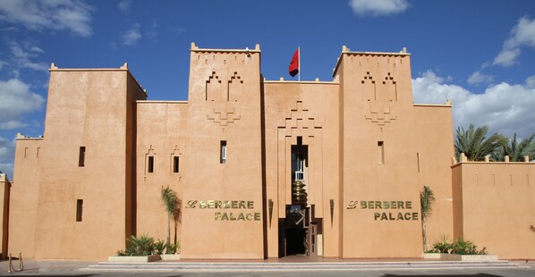 The exterior of the Berbere Palace with its distinctive architectural design and the name displayed on the facade. - Le Berbere Palace (Ouarzazate)