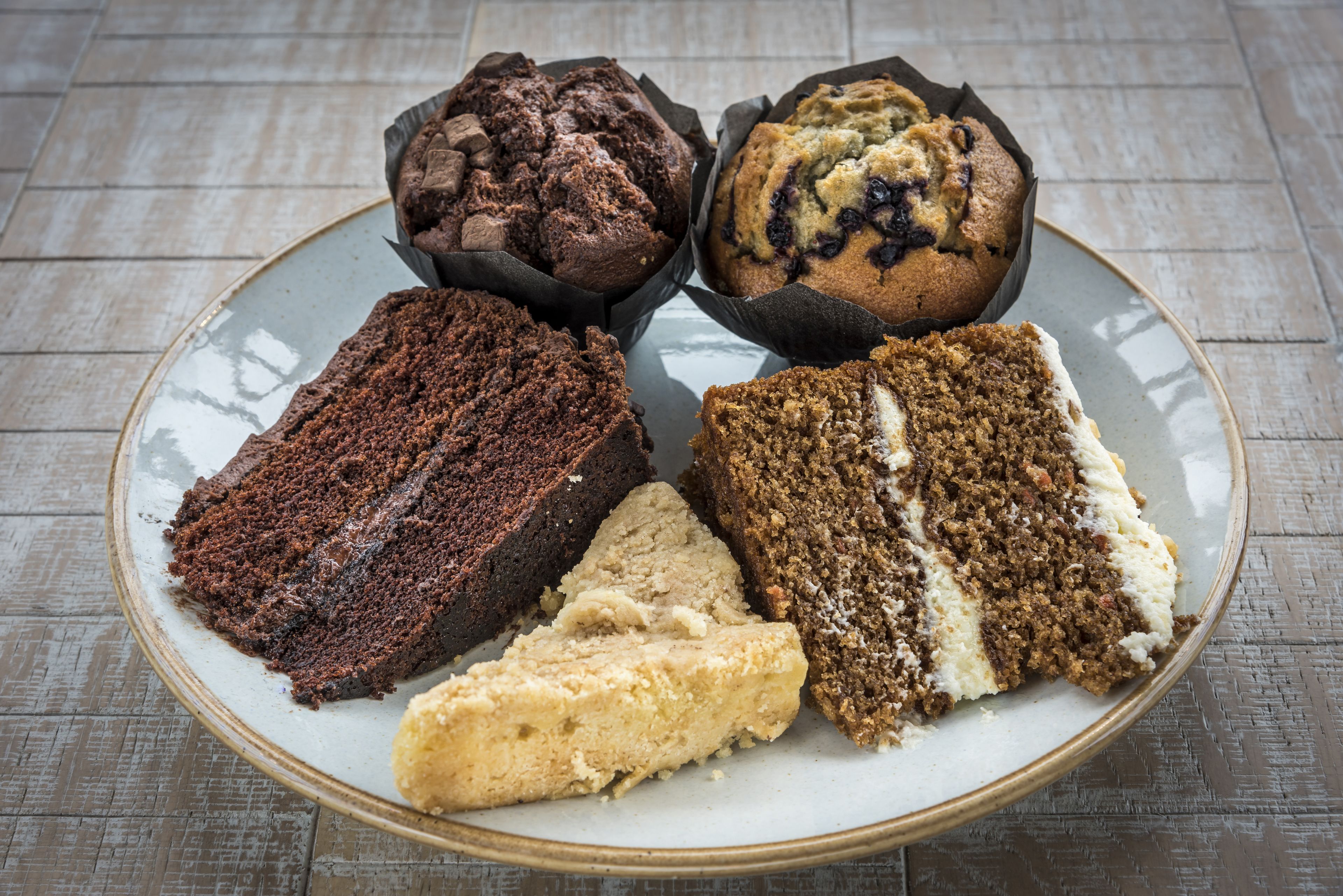 A plate with various types of baked goods, including muffins and cakes.