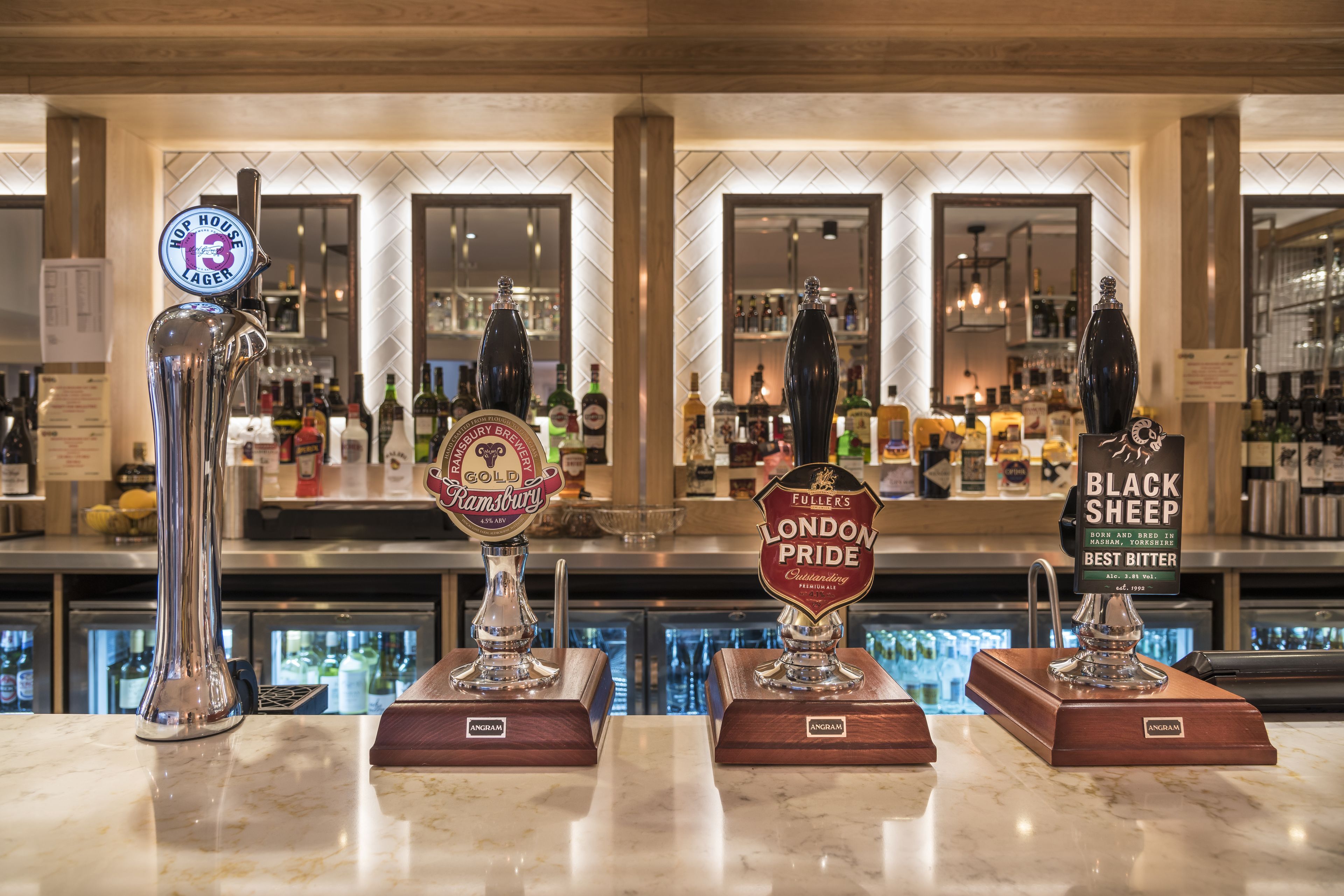 A bar with four beer taps labeled with different beer brands.