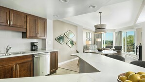 A modern kitchen with a large island, stainless steel appliances, and a dining area with a view. - Marriott's Royal Palms (Orlando)