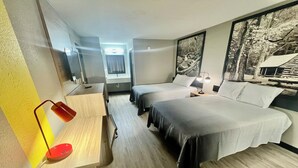 A hotel room with two single beds, a desk with a chair, a small table, and a large framed picture on the wall. - Super 8 by Wyndham Manchester TN (Manchester)