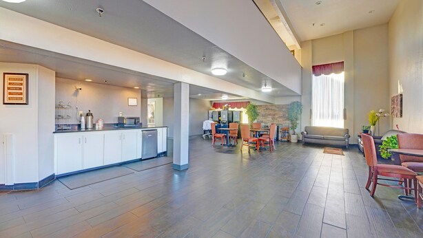 A spacious hotel lobby with a kitchen area, dining tables, and seating arrangements. - Travelers inn by OYO Wichita Falls (Wichita Falls)