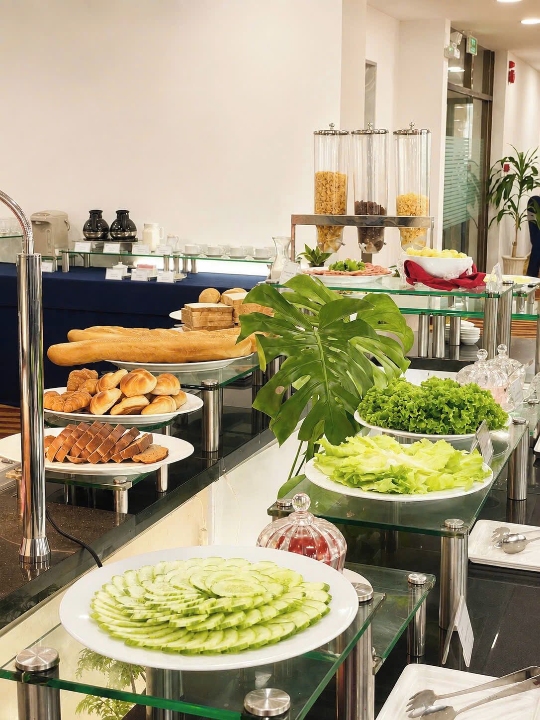 A buffet with various food items, including bread, pastries, and salads.