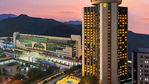 A modern hotel with a prominent tower, a spacious lobby, and a well-lit parking area. - Shangri-La Shenzhen (Shenzhen)