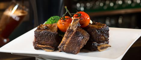 Un plato de comida con una jarra de cerveza Guinness al fondo.