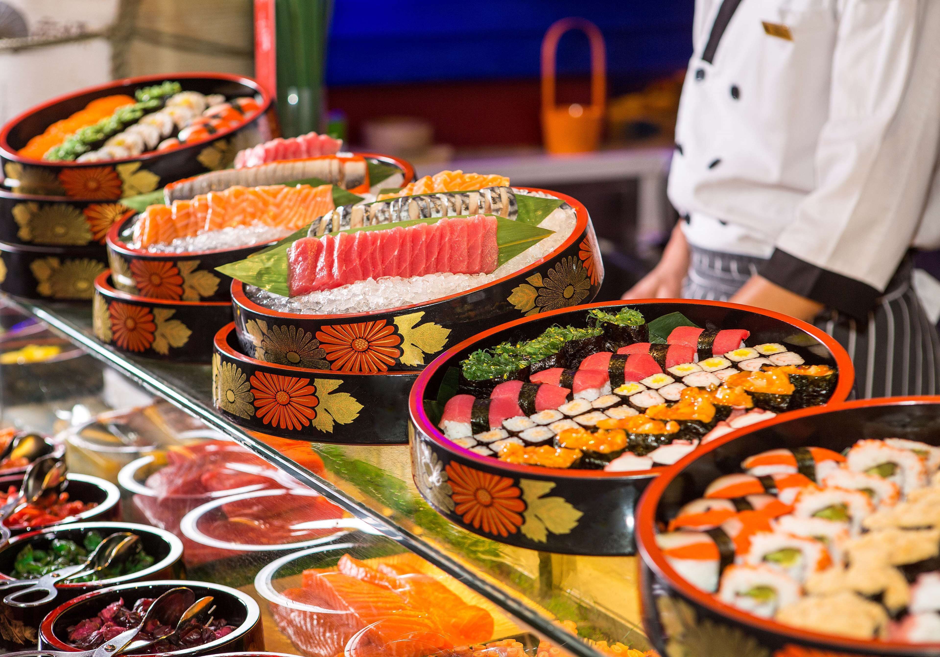 A sushi display with various types of sushi arranged in decorative bowls.