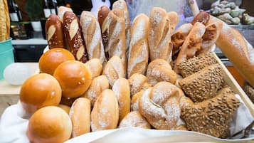A variety of breads displayed in a wooden tray.