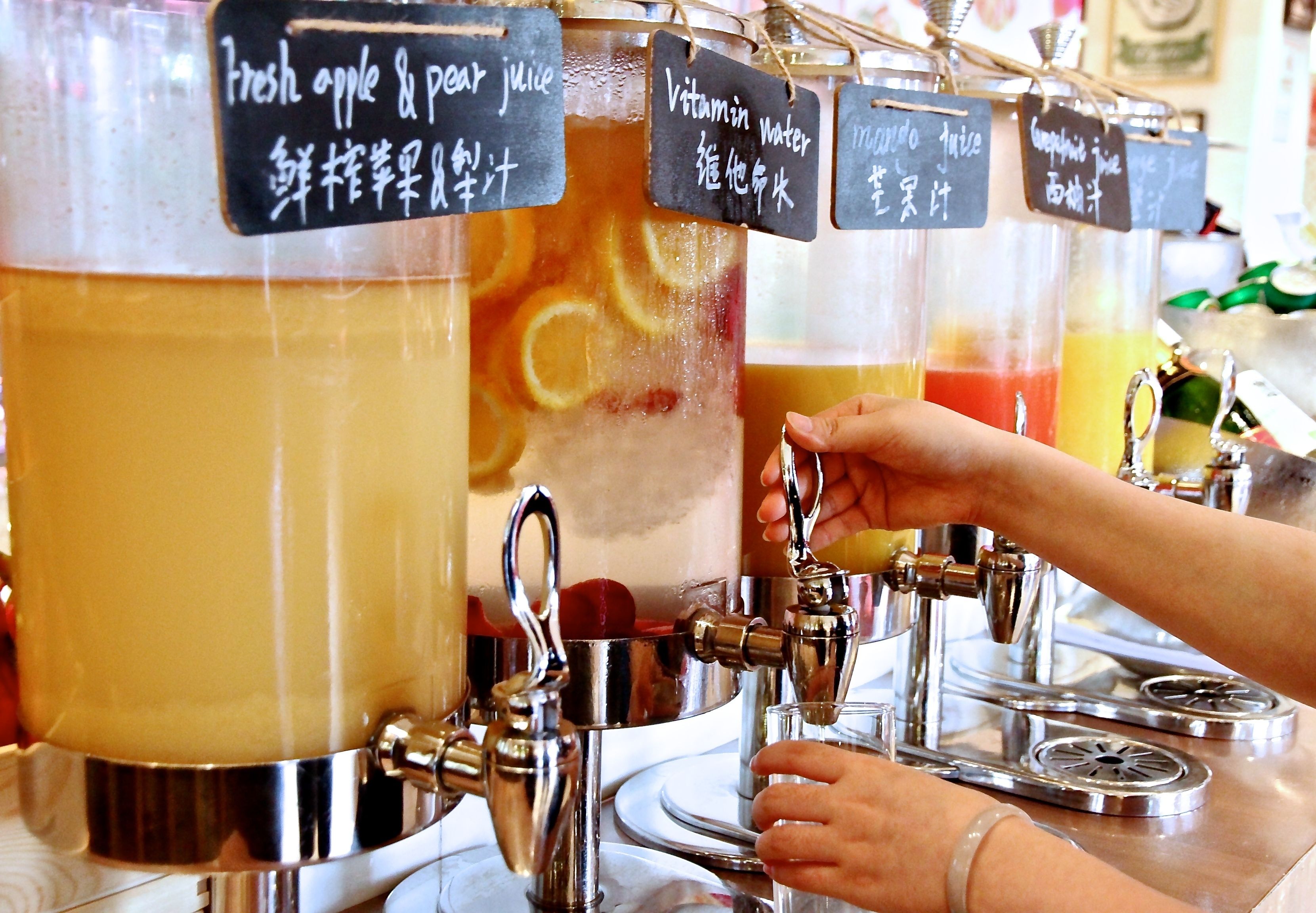 Un dispensador de bebidas con varias llaves, cada una identificada con diferentes opciones de bebidas.