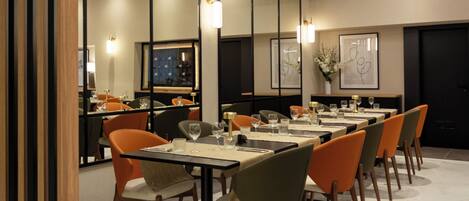 Un comedor moderno con varias mesas y sillas, una zona de bar y obras de arte enmarcadas en las paredes.