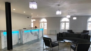 A spacious lobby with a reception desk, modern seating, and large windows.