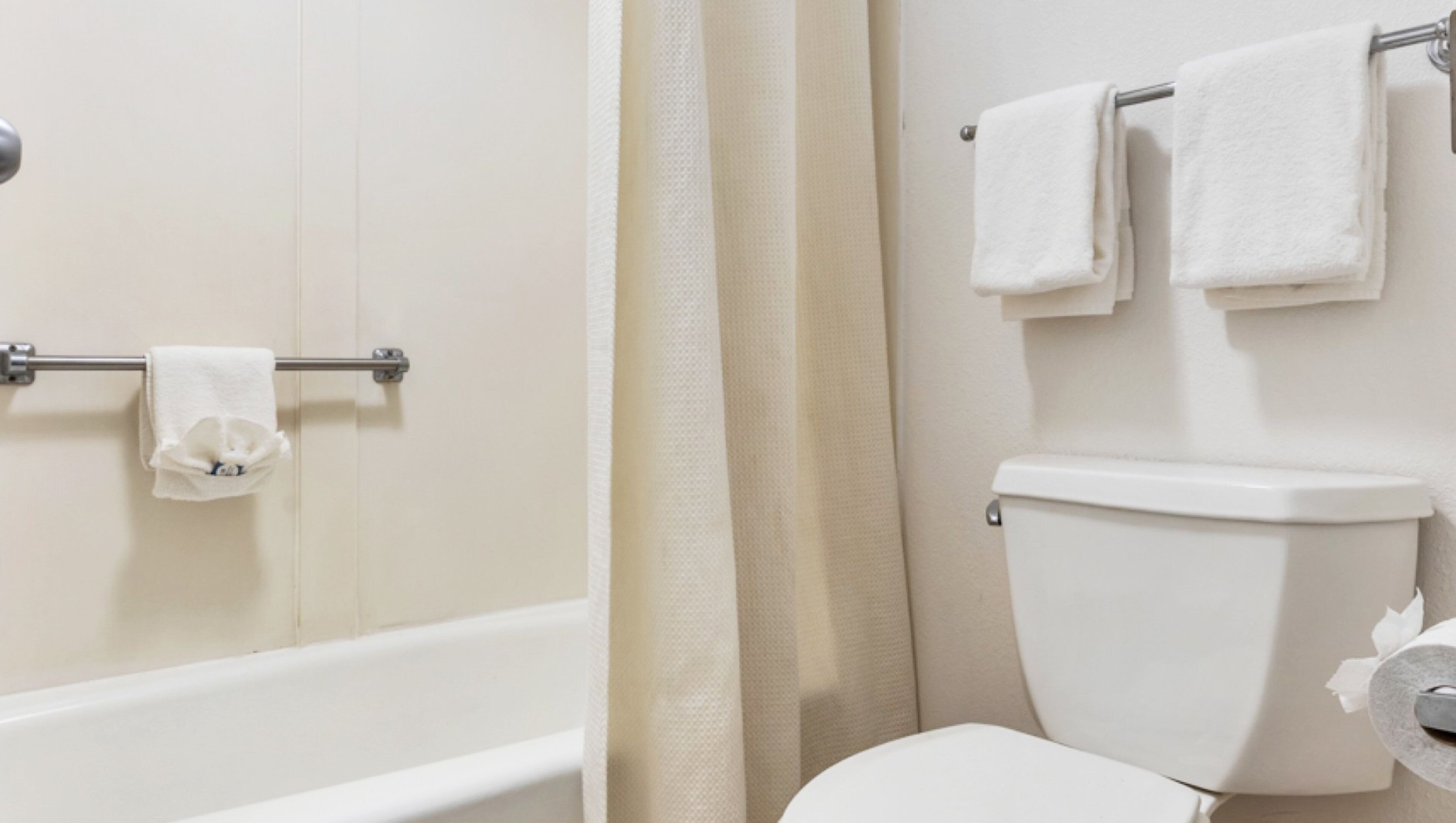 A bathroom with a bathtub, toilet, and towel rack.