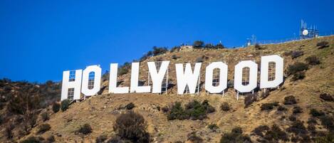 The Hollywood sign on a hill with a clear blue sky.