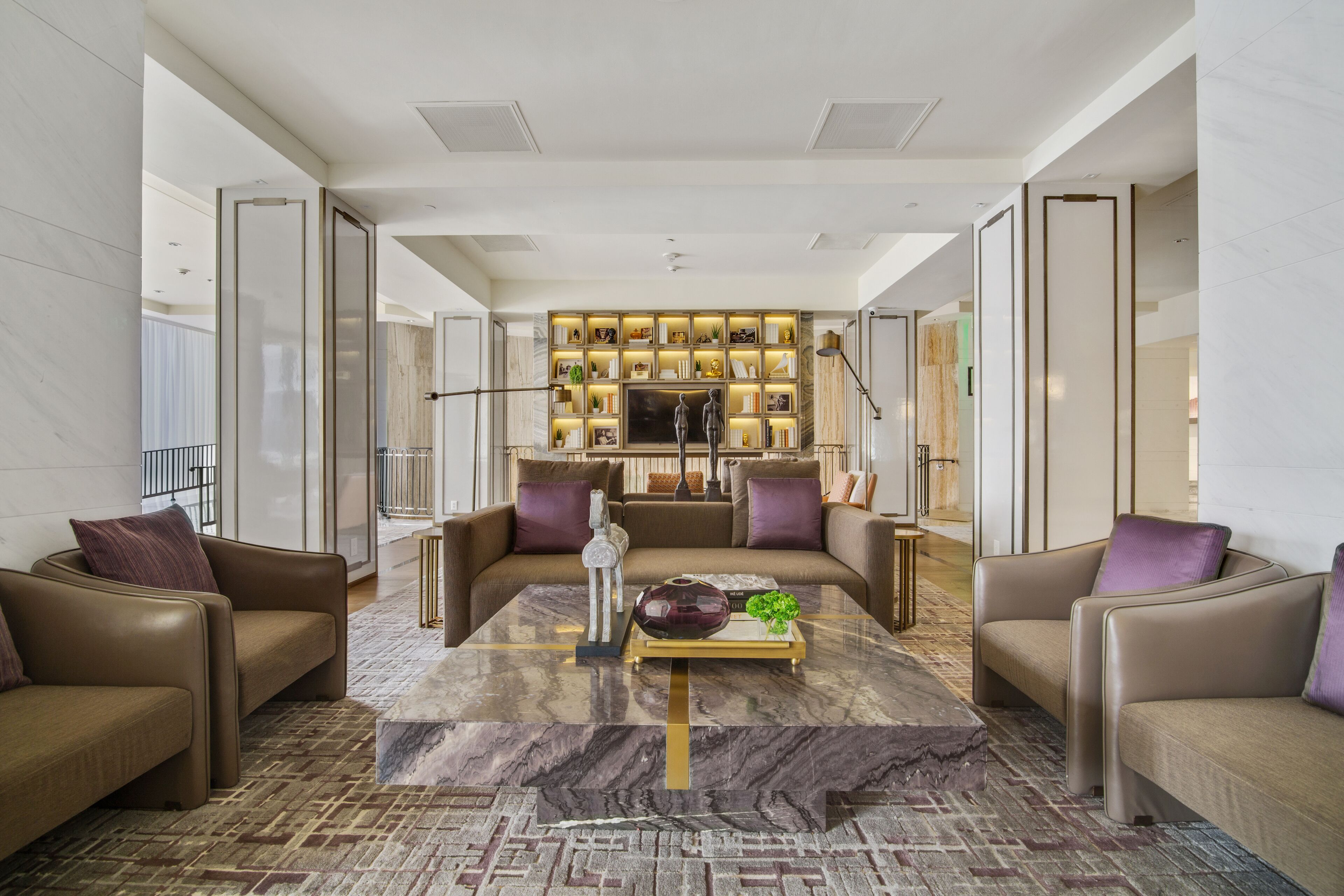 A modern living room with a central coffee table, two sofas, and a bookshelf.