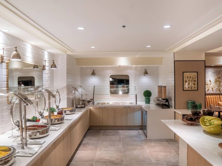 A modern kitchen with a central island, stainless steel appliances, and a variety of food items displayed on the counter.